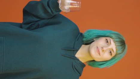 Vertical-video-of-The-young-woman-is-drinking-water.